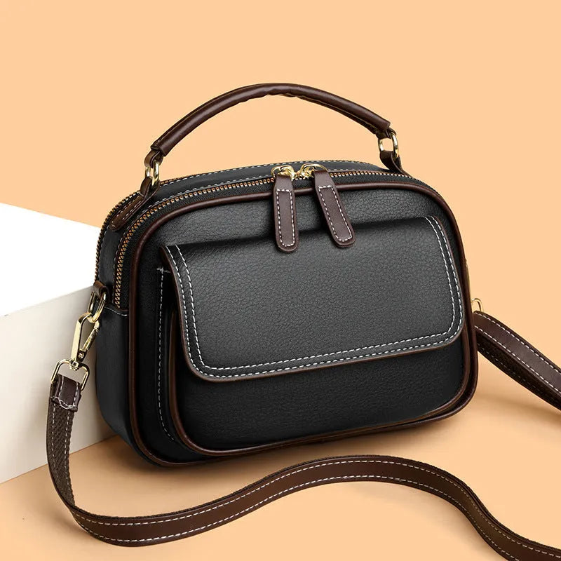 Women's black PU cross-body shoulder bag showing square shape and double connector straps