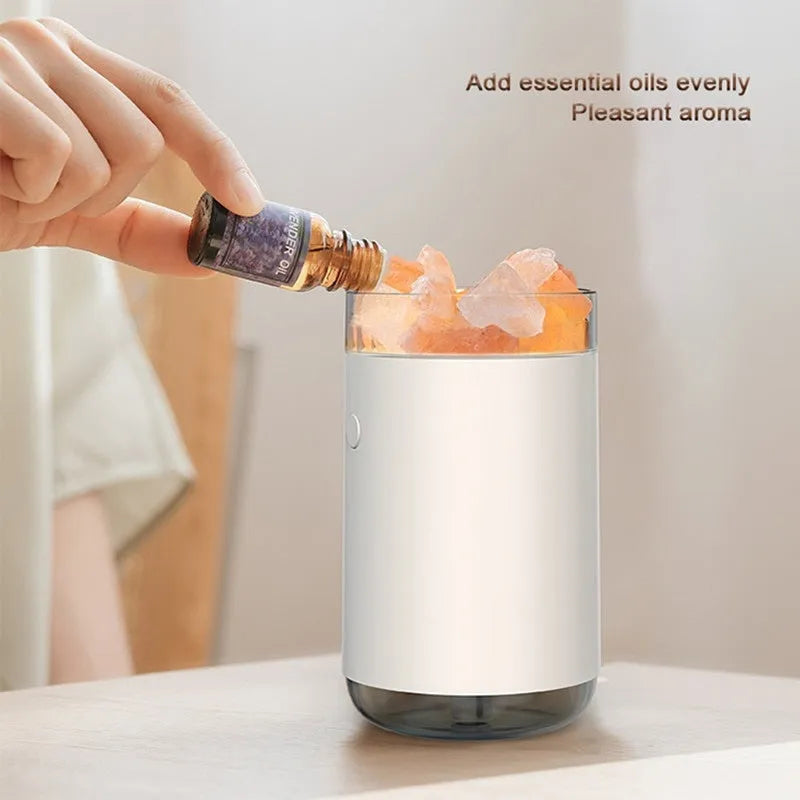 White desktop ultrasonic humidifier with crystal salt stone and LED lamp showing side view on table