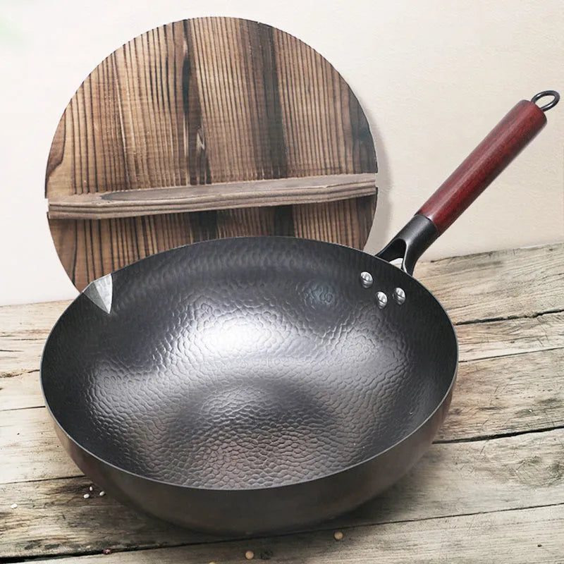Black traditional iron wok pan with wooden handle and induction base