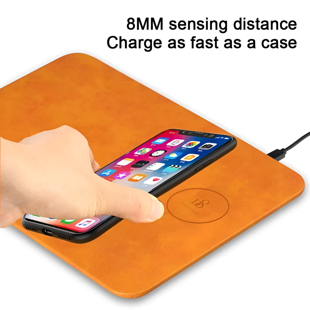Brown leather wireless charging mouse pad with Micro USB port on a wooden desk.