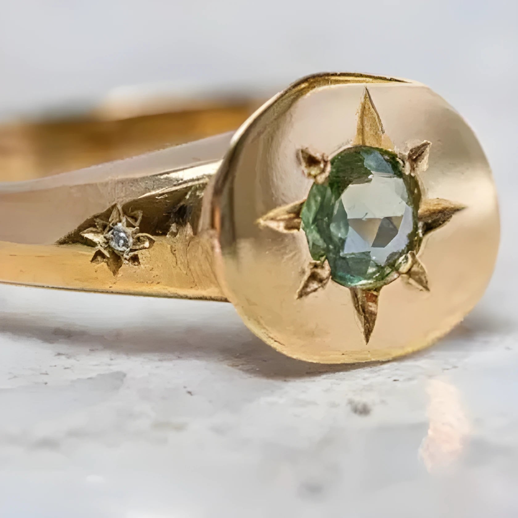 Gold-coloured star-shaped ring with a central oval zircon stone on an adjustable band.