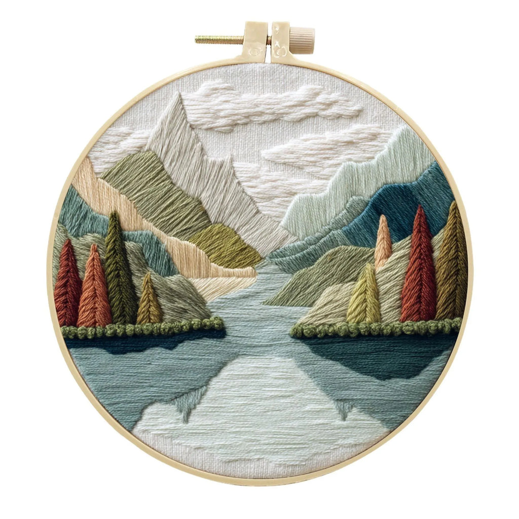 Embroidery DIY kit with cotton linen fabric, bamboo hoop, threads, and needles for landscape designs.