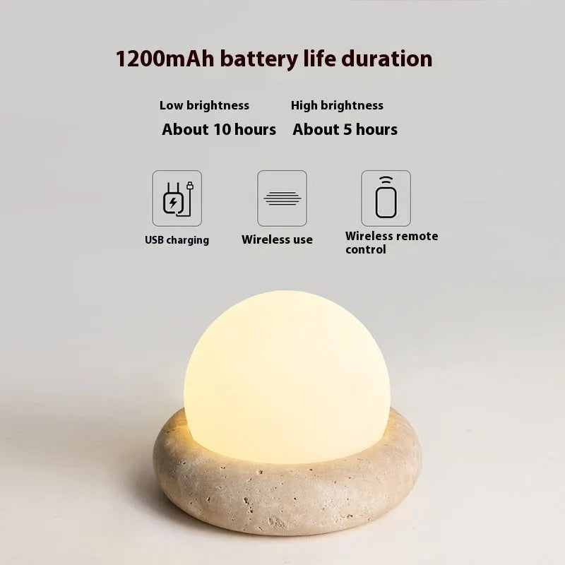 Cream coloured modern bedside night lamp with remote control on wooden table