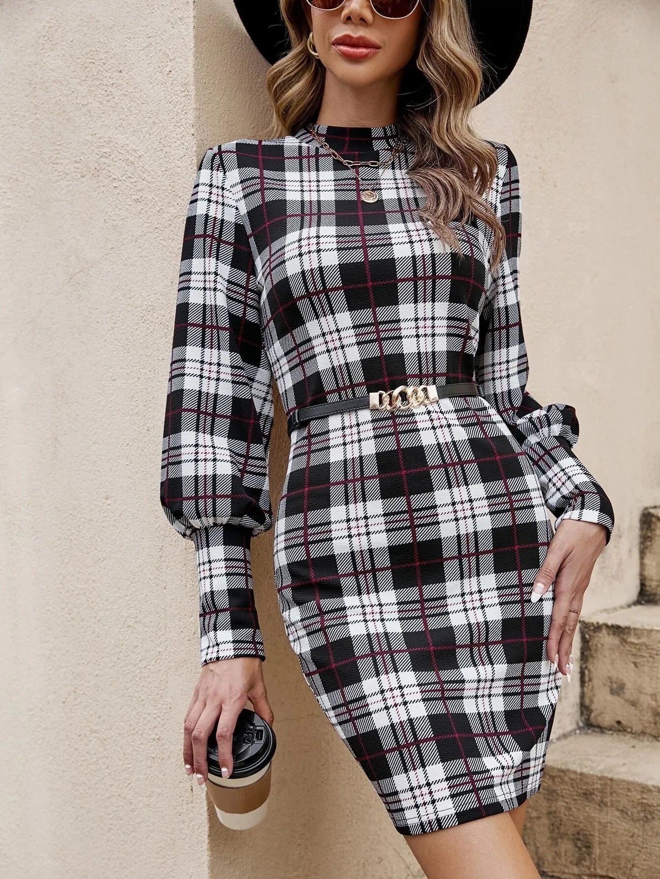 Black tight-fitting dress with voluminous lantern sleeves and decorative leather stitching detail.
