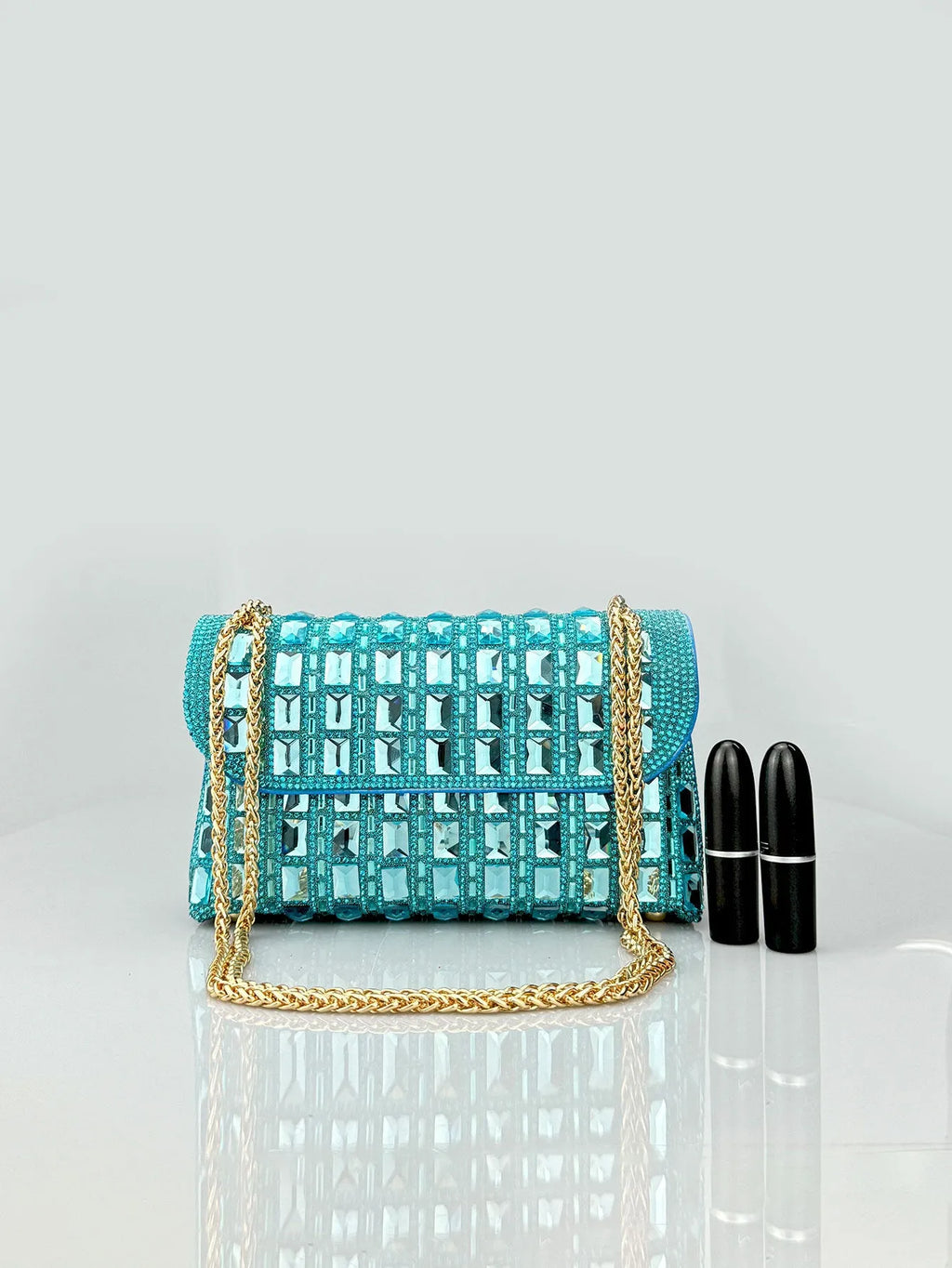 Silver rhinestone chain clutch bag with square shape and internal phone pocket on a table.