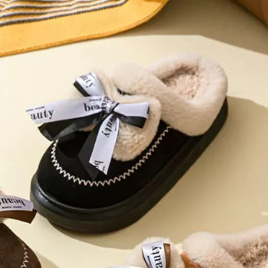 Women's beige suede half slippers with a thick sole and wool lining on a wooden floor.