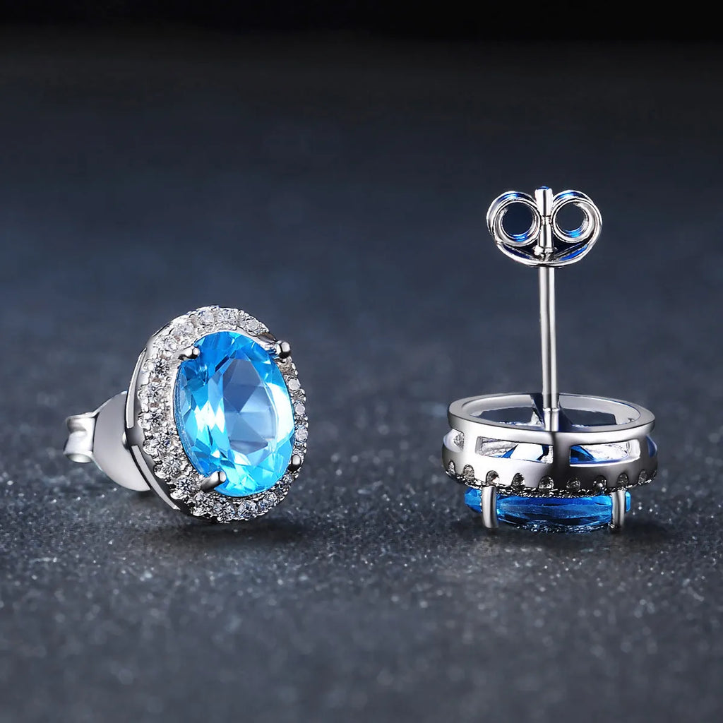 925 sterling silver four-piece jewellery set with blue topaz gems showing geometric earrings, ring, necklace, and pendant