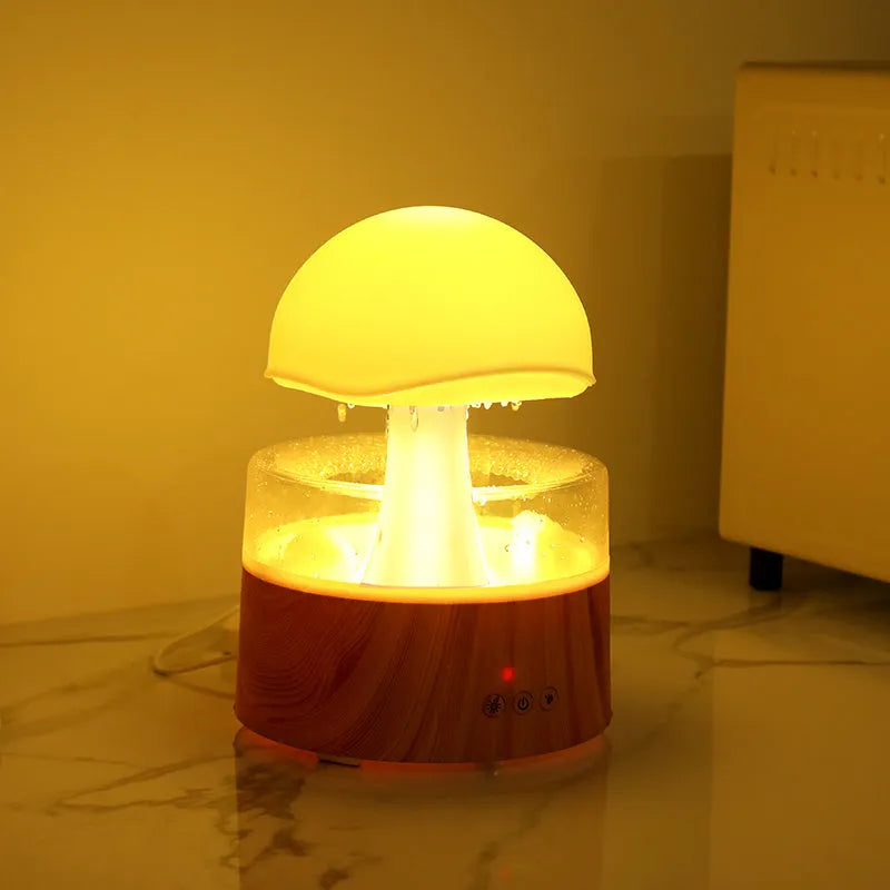 White cloud-shaped humidifier and aroma diffuser with LED lights and simulated raindrops.