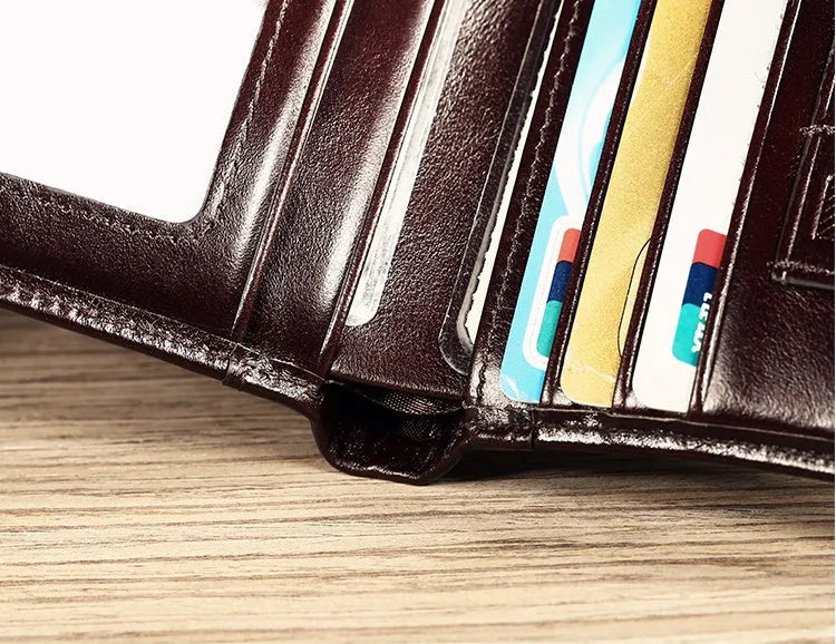 Men's brown leather bifold wallet open to show photo slot, card slots, billfold, and coin pocket.