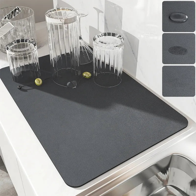 Square black kitchen drain mat with rubber backing placed under coffee machine on countertop