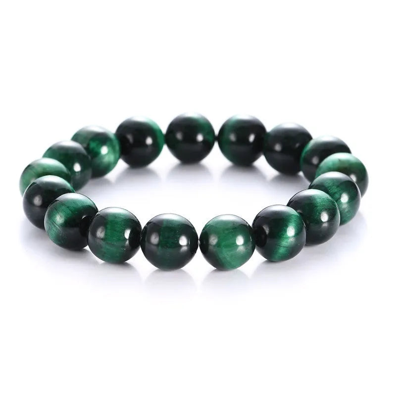 Natural green tiger eye stone bracelet with polished spherical beads in geometric design on wrist.