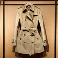Khaki women's double-breasted polyester trench coat with flight sleeves on a hanger