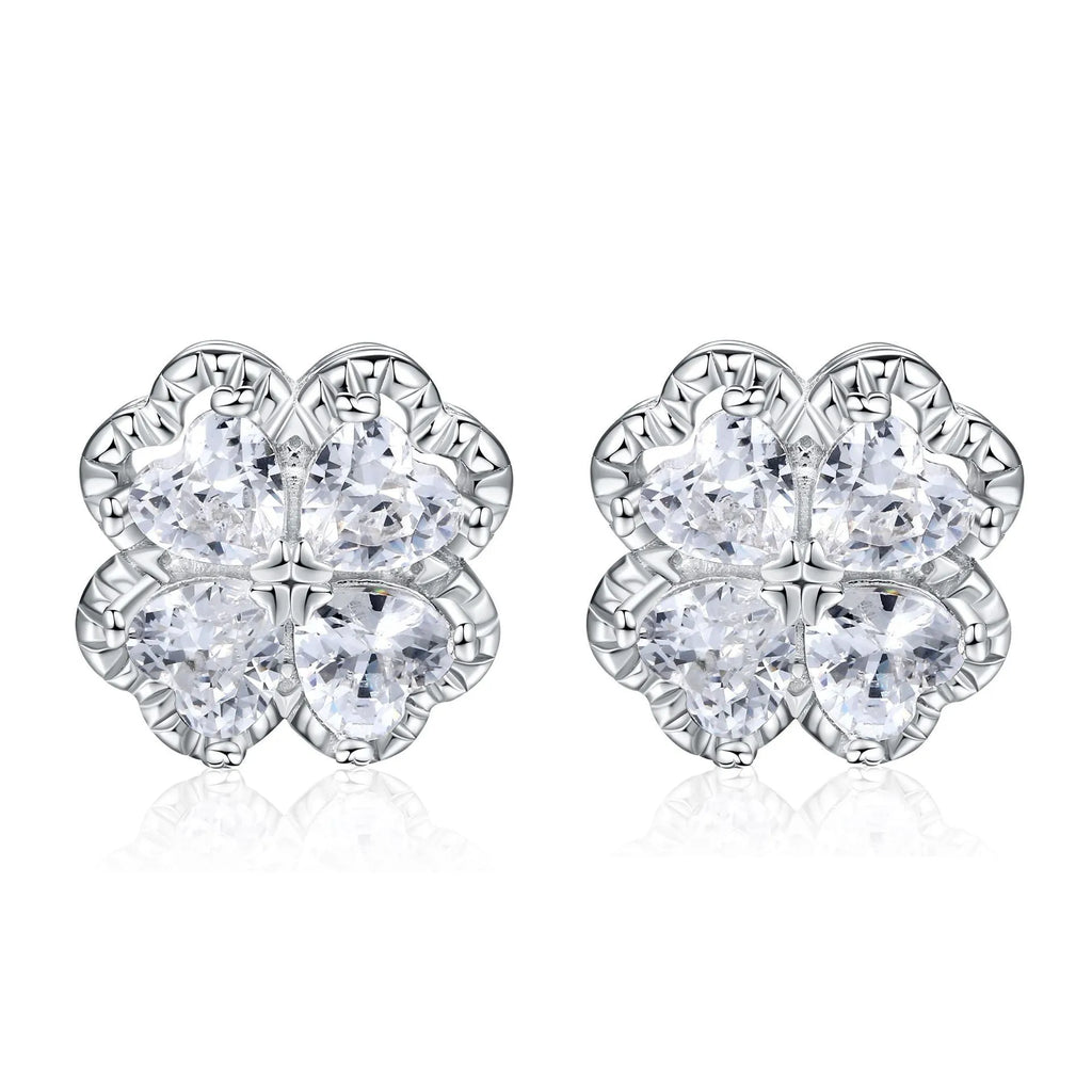 A pair of 925 silver earrings with a four-leaf clover charm and heart-shaped zircon stones in white gold colour.