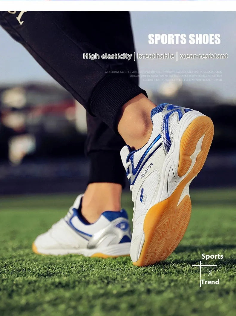 White and blue table tennis sneakers with synthetic leather upper and rubber sole on a court surface.