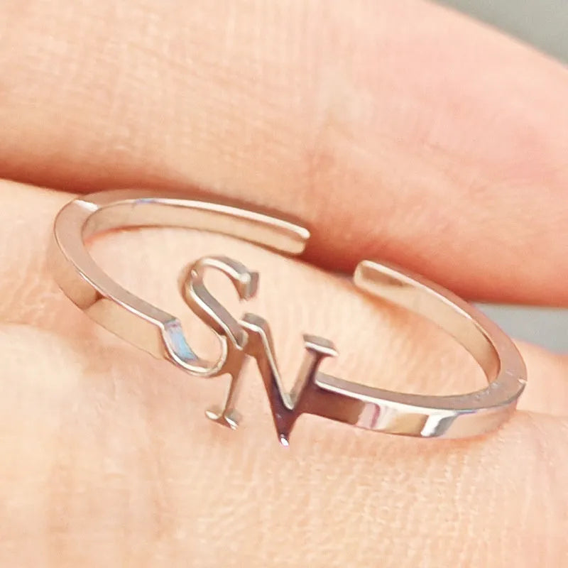 Customised 2 letters open ring in stainless steel with gold electroplated finish on a plain background