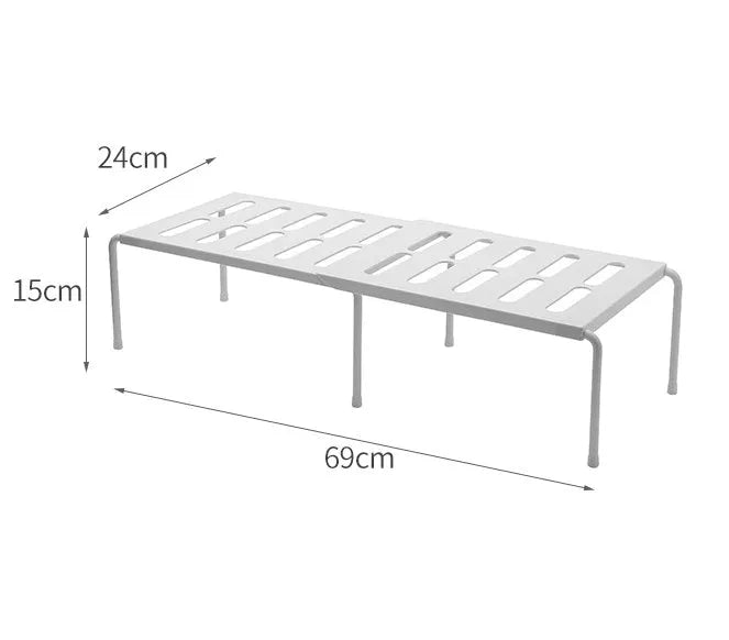 White telescopic kitchen storage rack with adjustable height on a countertop