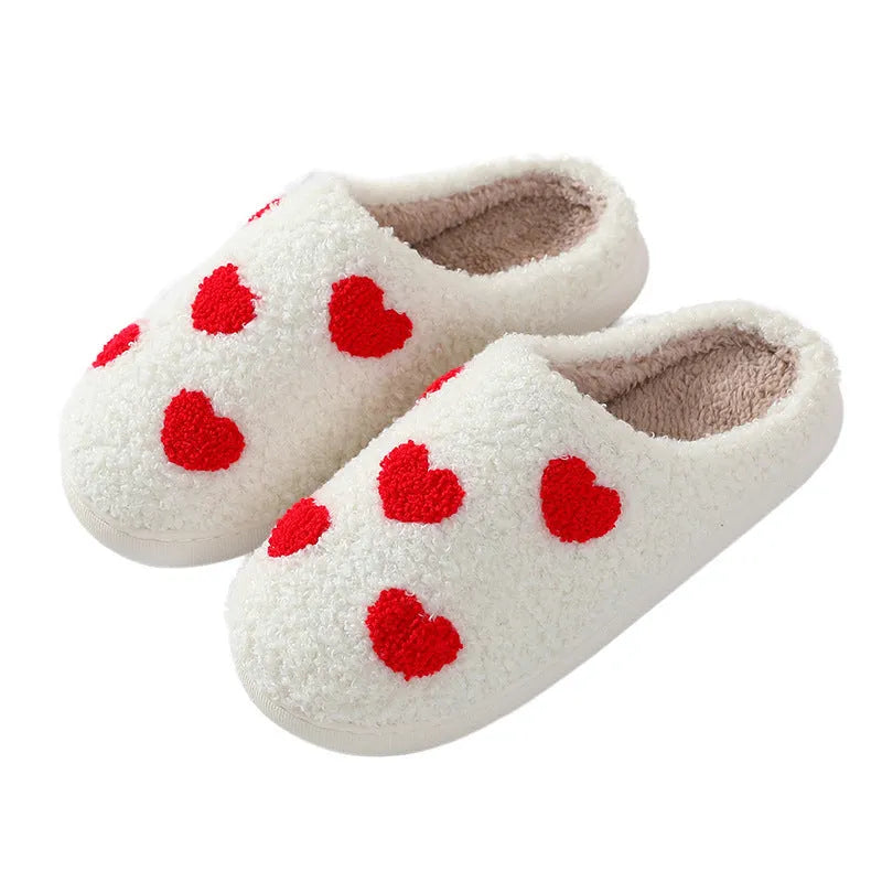 Women's plush slippers with cartoon love design, showing round toe and non-slip PVC sole.