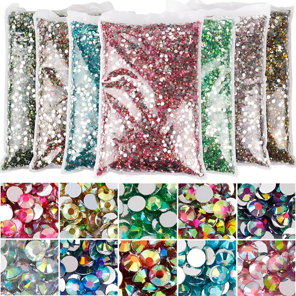Assortment of multicoloured flat back resin rhinestones in various sizes for nail art and craft projects.