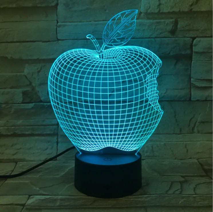 Colourful 3D fruit-shaped acrylic LED night light with touch controls on a dark surface.