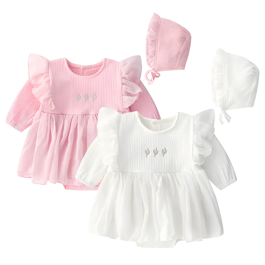 A baby girl wearing a fluffy cotton princess dress in pink, for a christening or birthday.