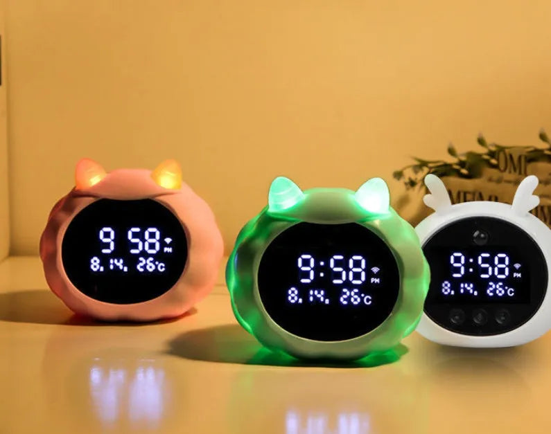Silicone smart alarm clock with voice control, human body sensor, and luminous display on a bedside table.