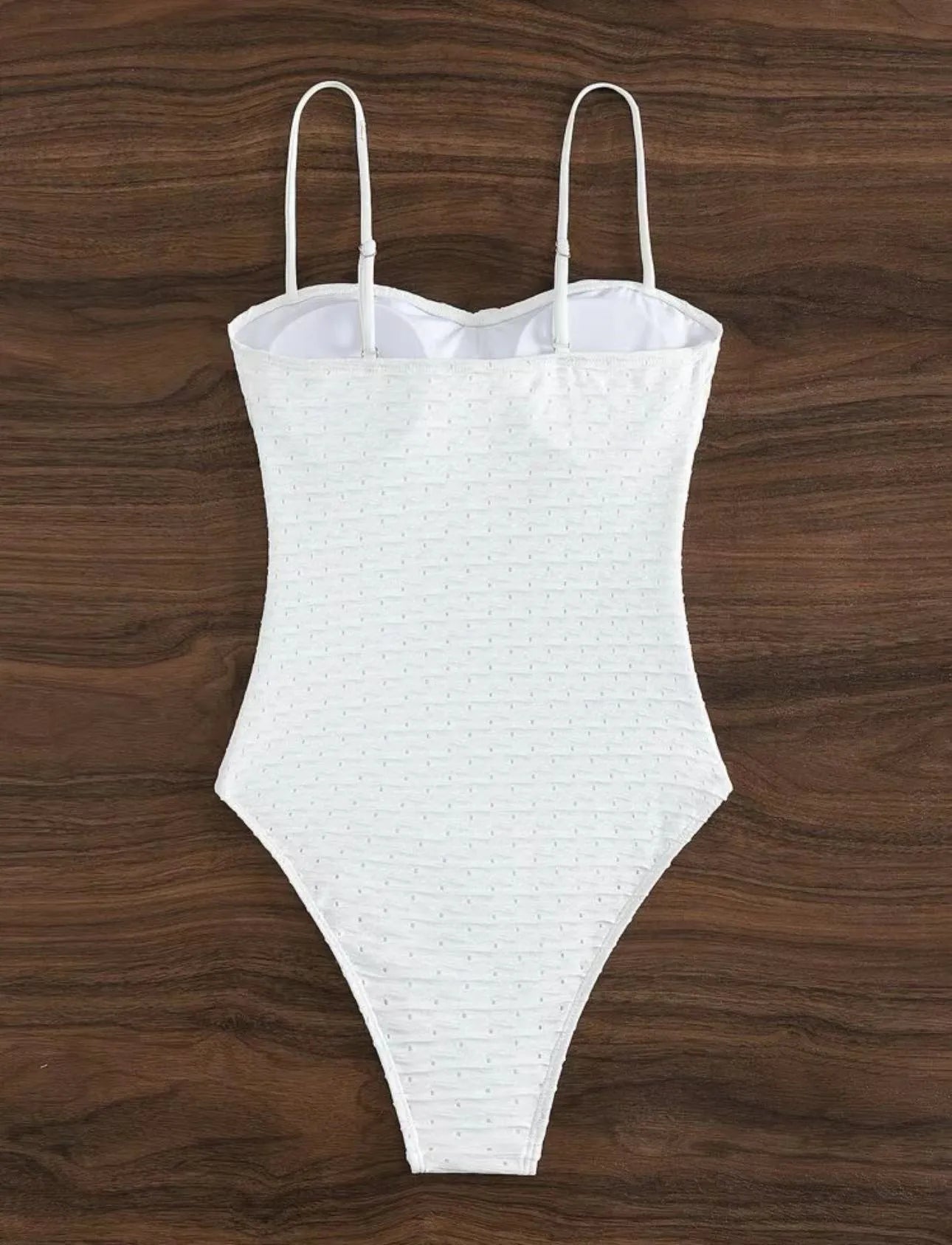 White one-piece women's swimsuit with sling straps and brief styling on mannequin
