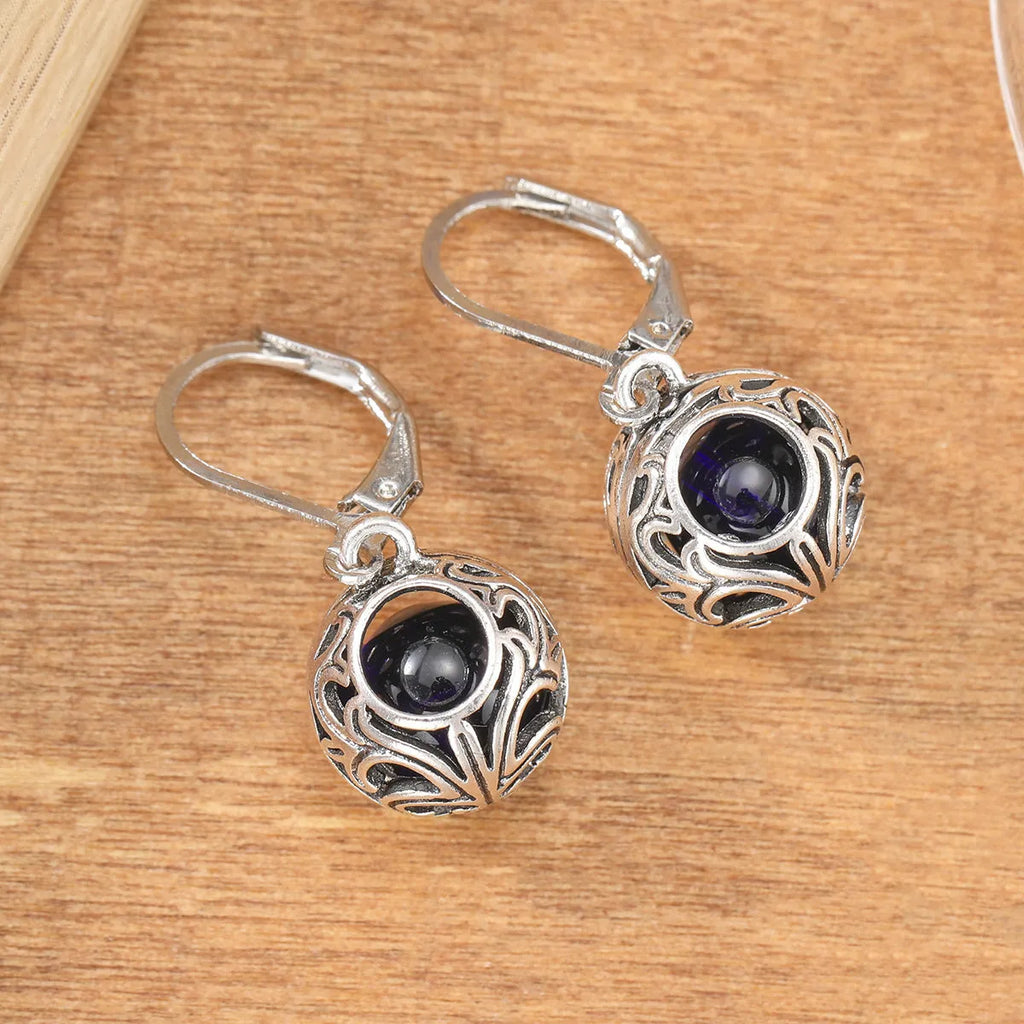 Silver geometric earrings with blue gemstone pendants and hollow engraving details
