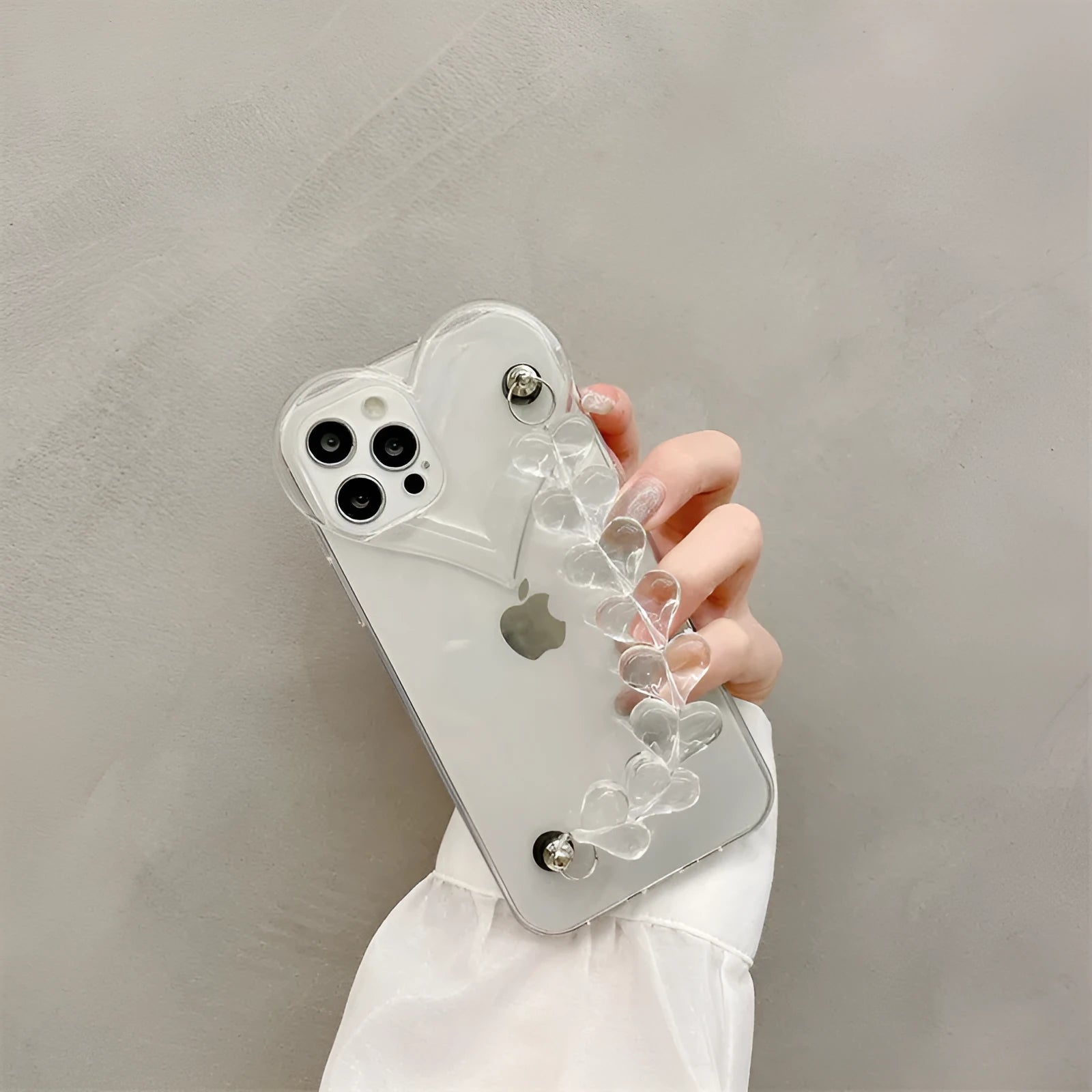 Transparent soft TPU iPhone case with a decorative silver love bracelet chain attached.