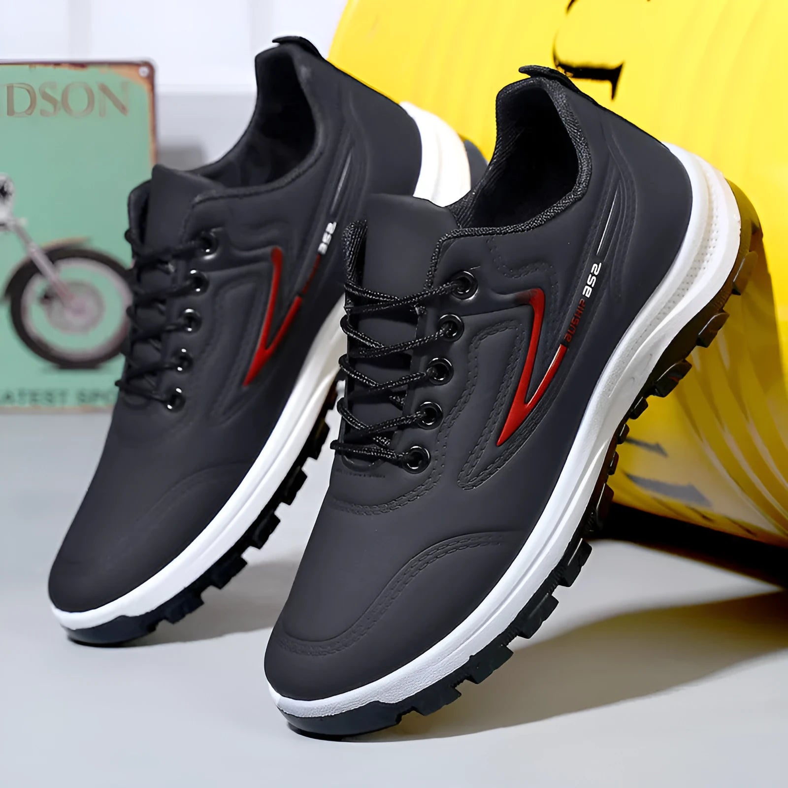 Black and grey waterproof leisure sports shoes with artificial PU upper and lace-up closure on a flat heel.