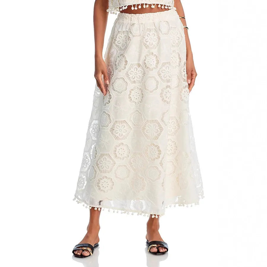 White women's retro-style two-piece suit with sleeveless top and embroidered long skirt.