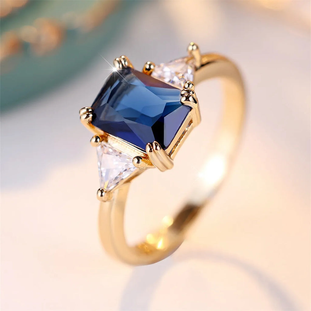 Rectangular copper ring with gold sapphire blue finish shown on model finger