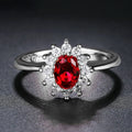 Women's floral copper ring with a blue moissanite centre stone on a model's finger.
