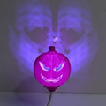 Plastic pumpkin-shaped decorative lamp with a USB cable, glowing either yellow or purple.