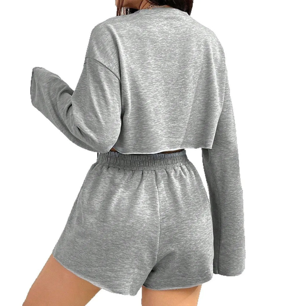 Grey women's polyester tracksuit set with long sleeve t-shirt and matching shorts laid flat.