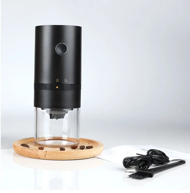 Black portable electric coffee grinder with transparent chamber showing coffee beans, USB-C charging port visible