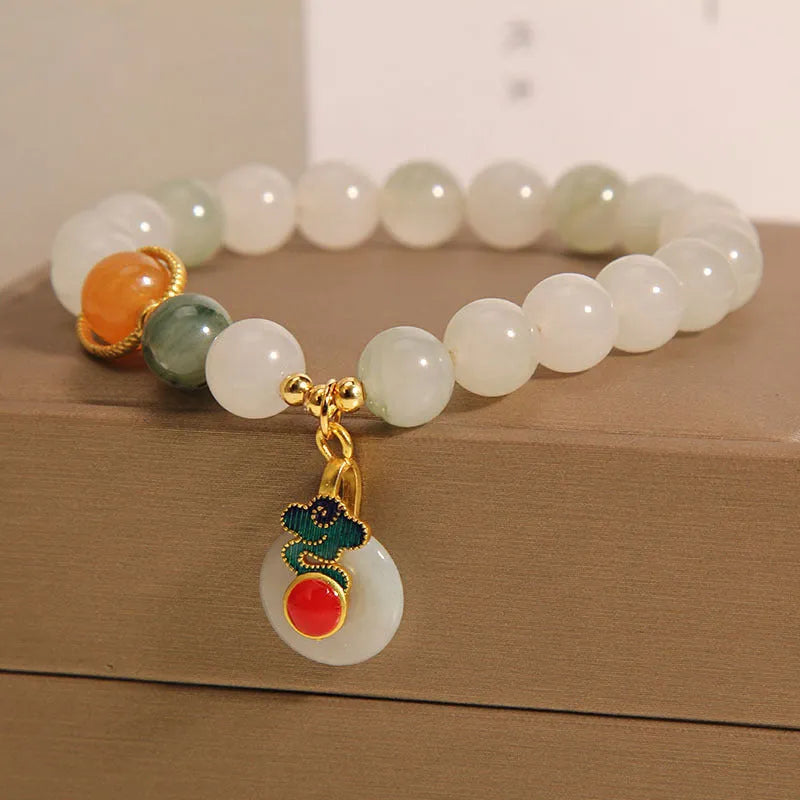 Women's ice jade bracelet with xiangyun pattern, peace buckle, and pearl accents on a white background.