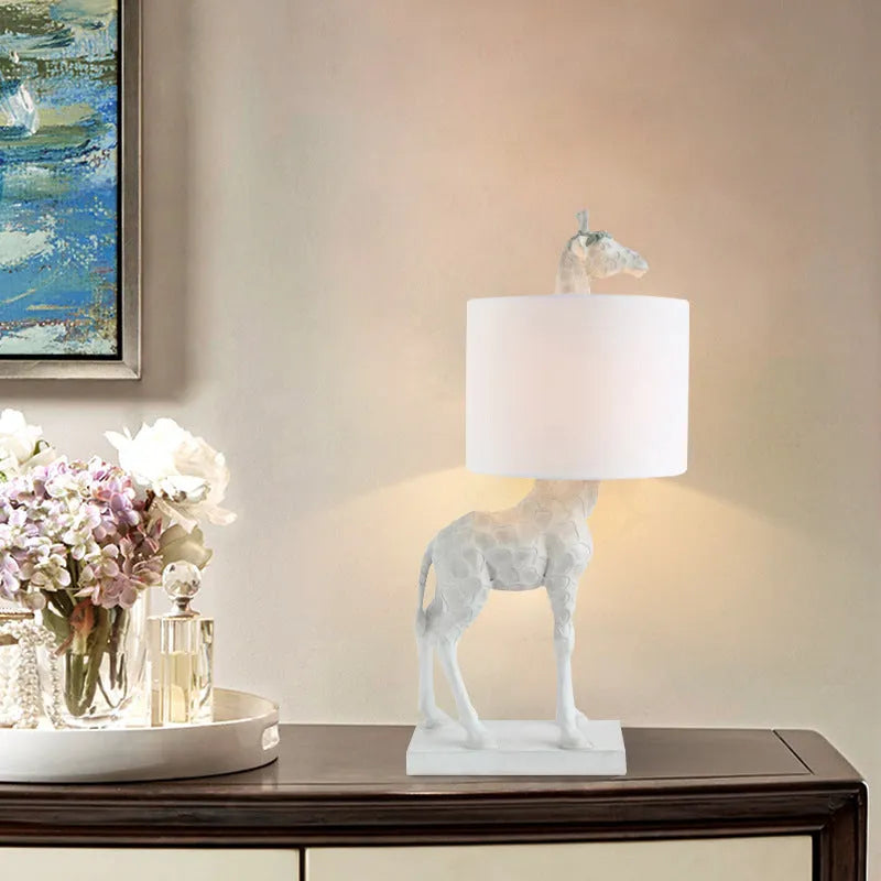 White or gold giraffe table lamp measuring 66cm tall with resin and cloth construction