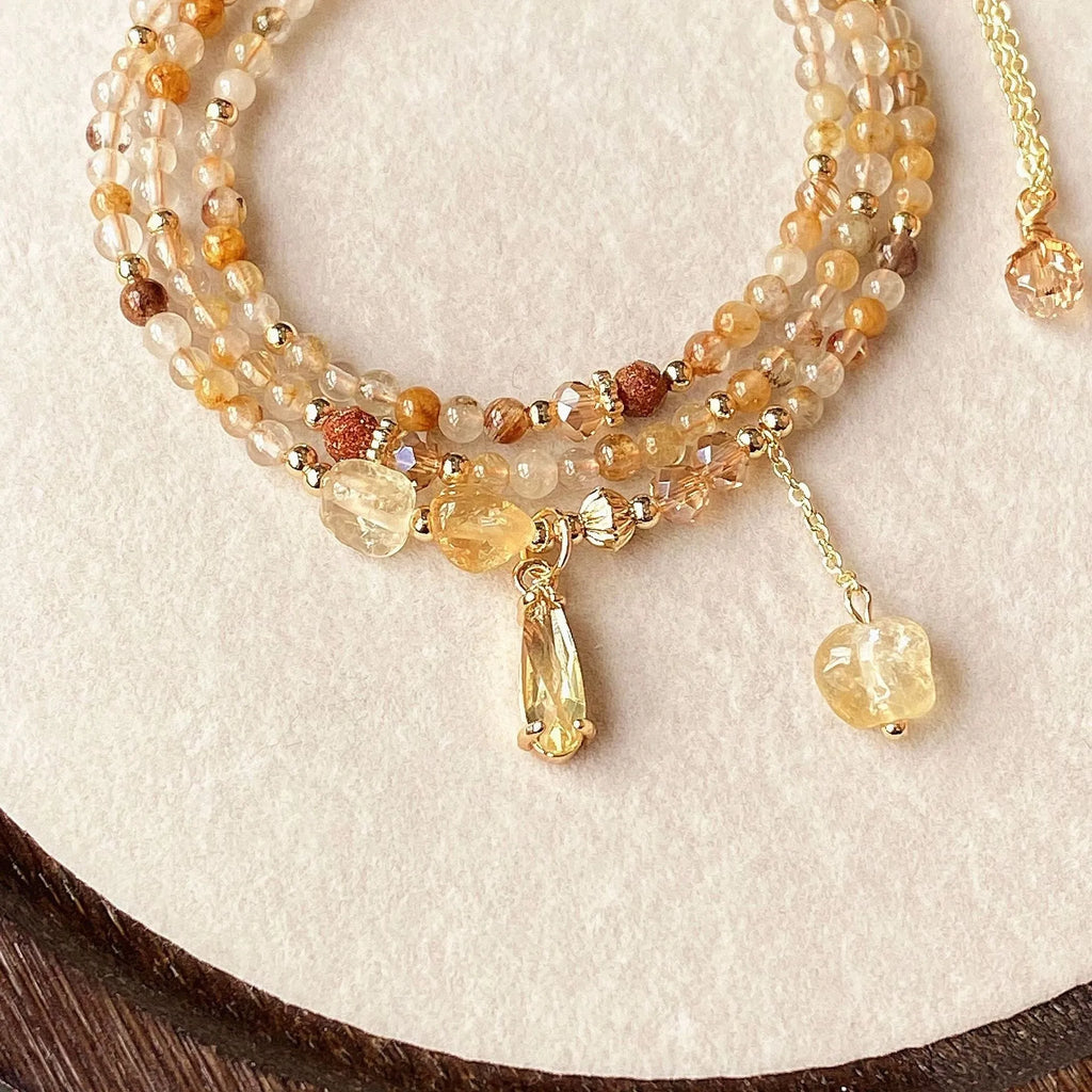 Gold electroplated bracelet with three circles of caramel citrine and a Saturn charm.