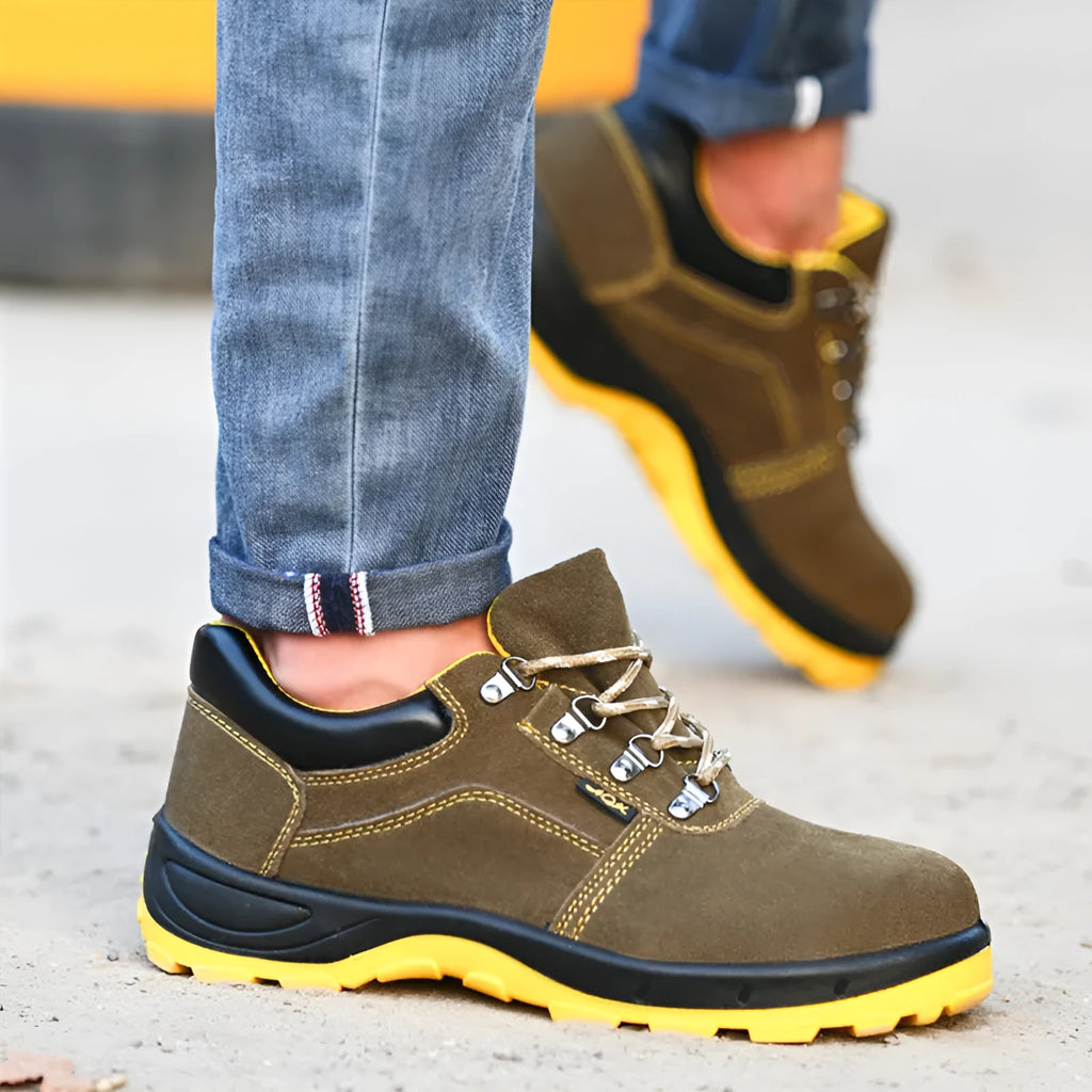 Bronze coloured low-cut cow suede leather safety shoes with a steel toe cap on a work surface.