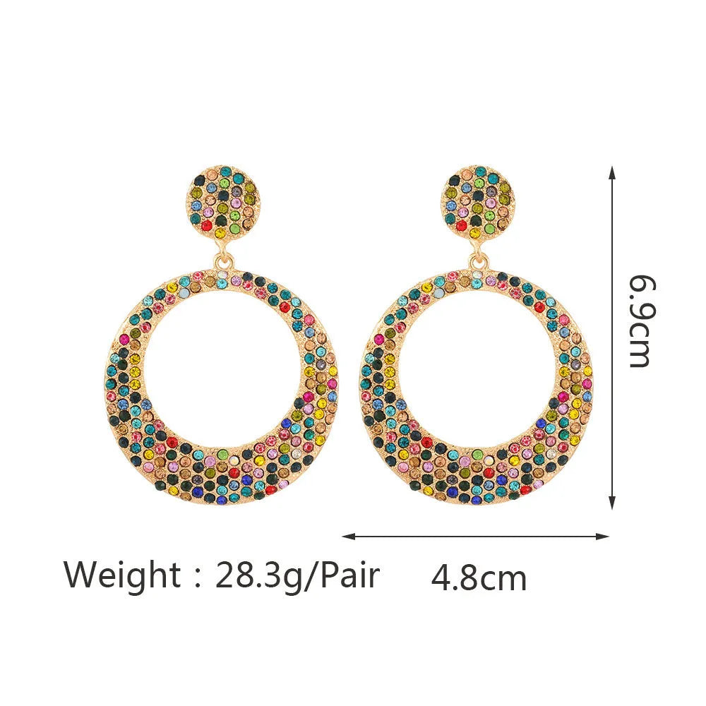 A pair of large round pendant earrings with colourful diamond-like accents on a metal alloy base, cartoon style.