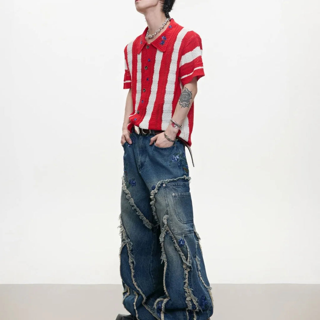 Man wearing a red and black patchwork striped knitted short sleeve shirt with a loose fit.