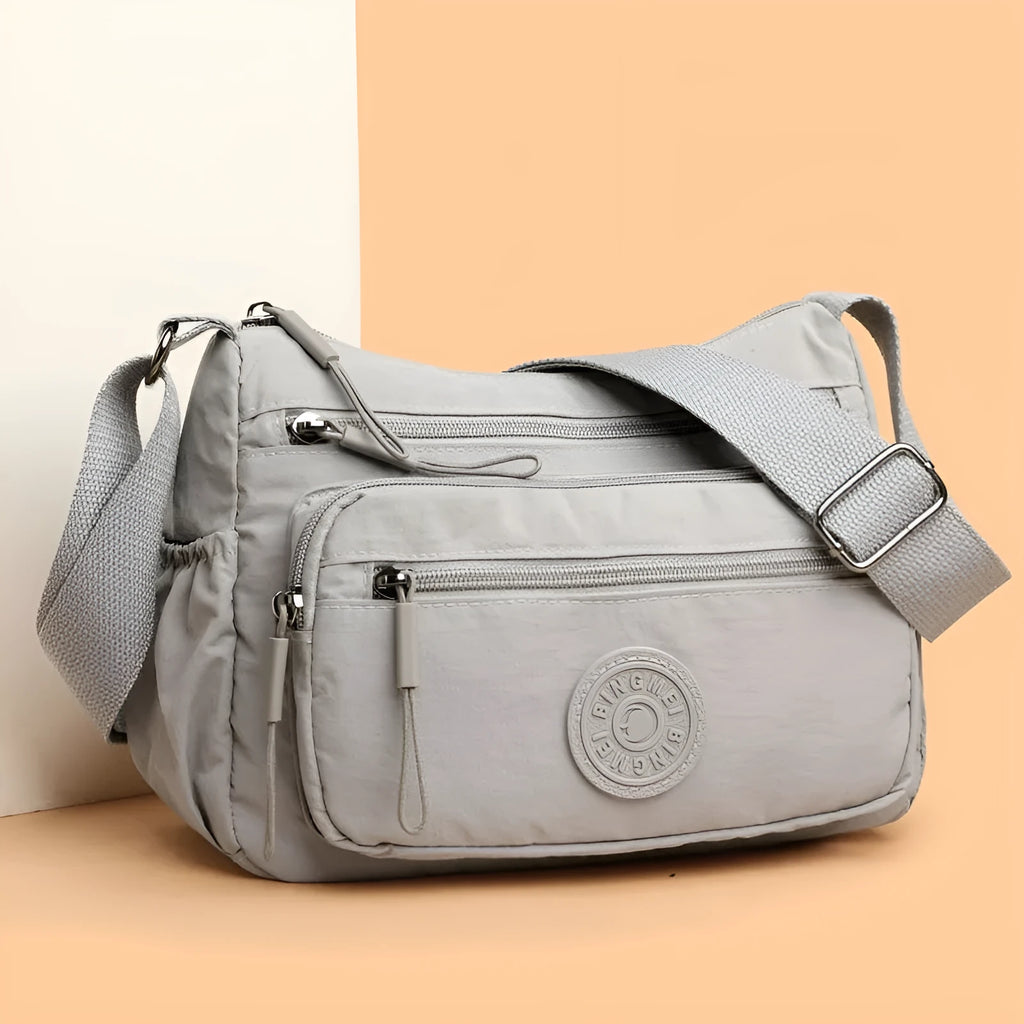 Water-repellent nylon crossbody cloth bag in black, grey or red with internal zipper compartments