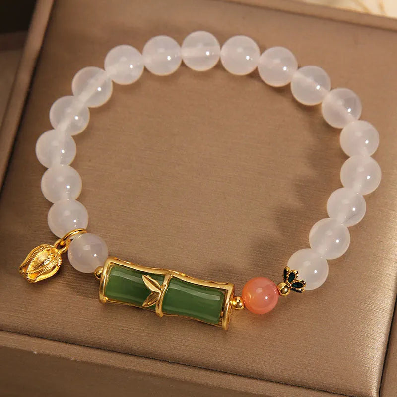 Women's white agate and jade beaded bracelet with bamboo joint connector in retro Chinese style.