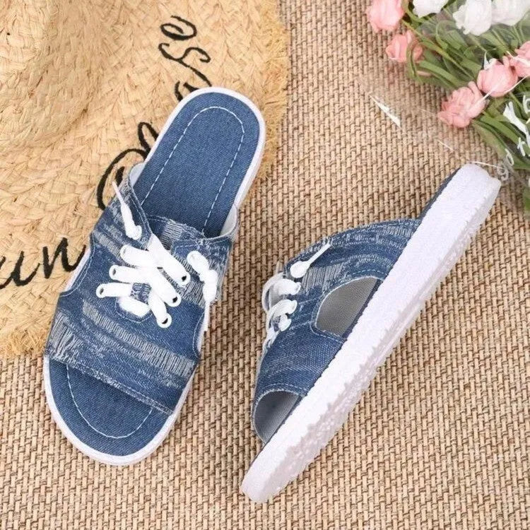 Blue women's flat canvas slippers with cloth lining and a rubber sole, shown in Roman style.