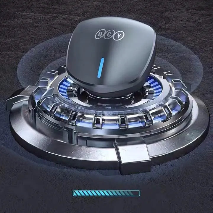 Grey QCY-G1 wireless Bluetooth gaming headset with charging case and ear tips on a table.