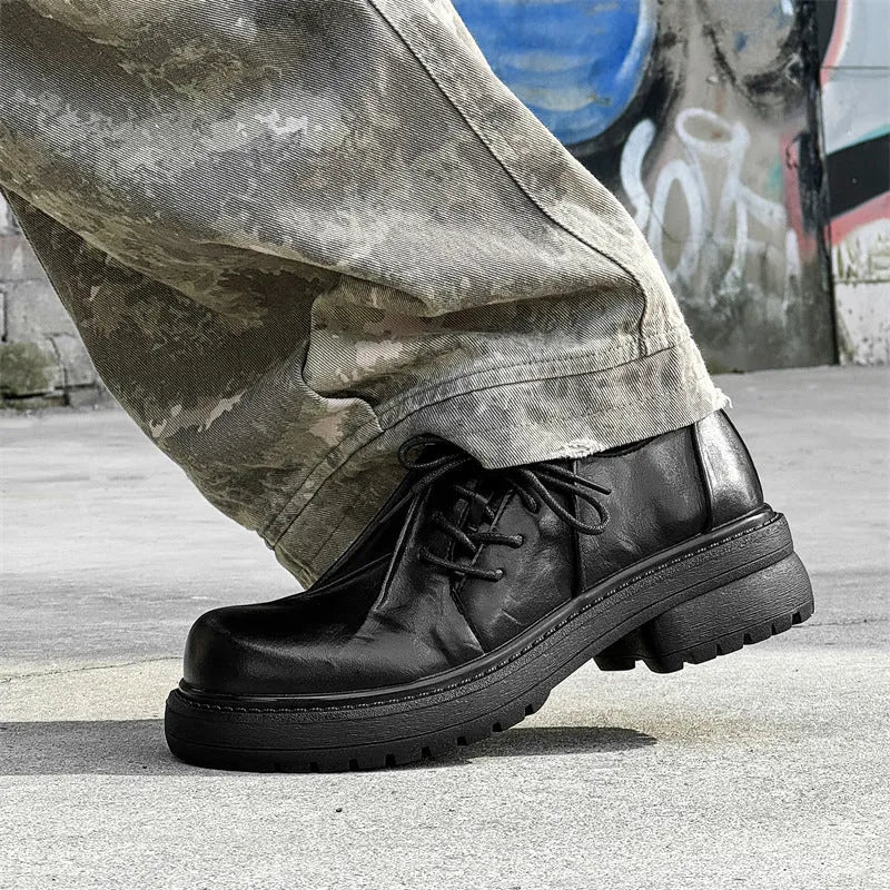 Black leather platform shoes with a warped head design and round toe on a rubber sole.