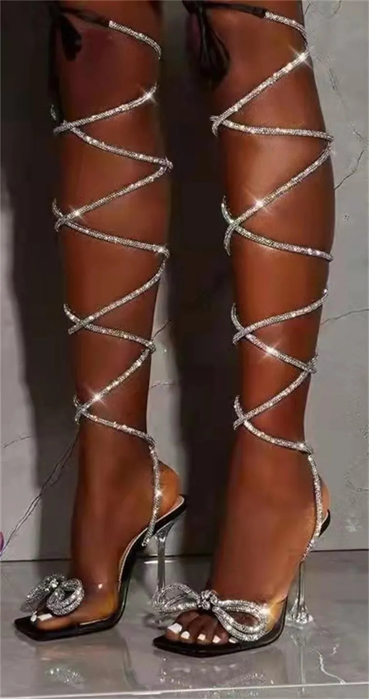 Plus size women's black strappy high-heel sandals with glittering rhinestone straps and a square toe.