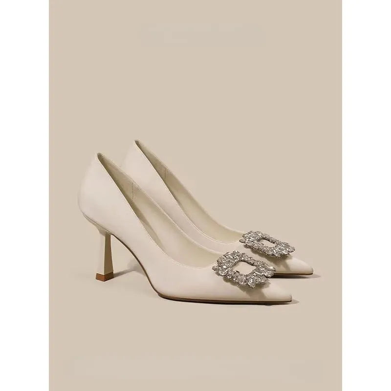 Women's pointed toe stiletto high heels in beige and black, showing low-cut design and thin heel.