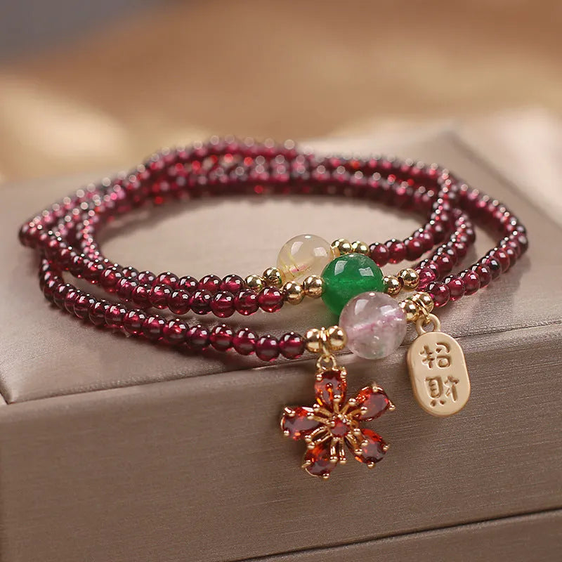 Women's natural crystal bracelet in pomegranate red cherry blossom colour with sequin details on strap.
