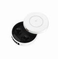 Small black wireless semi-in-ear headphones placed inside their white wireless charging case.